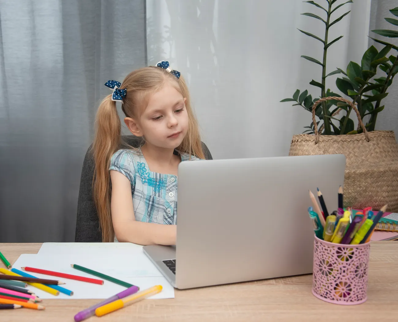a girl sitting at a desk with a laptop