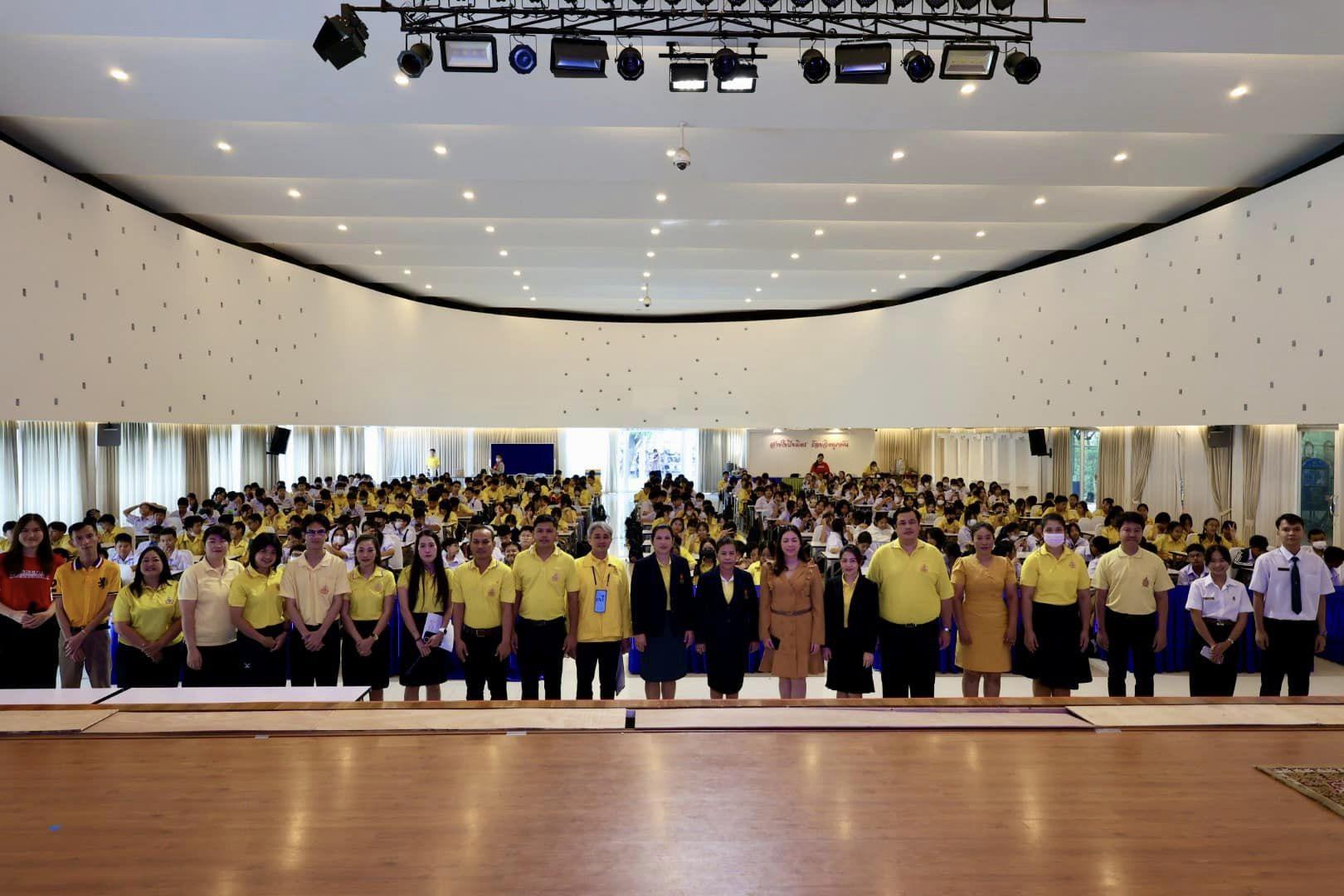 a group of people in yellow shirts and black pants standing in a large room